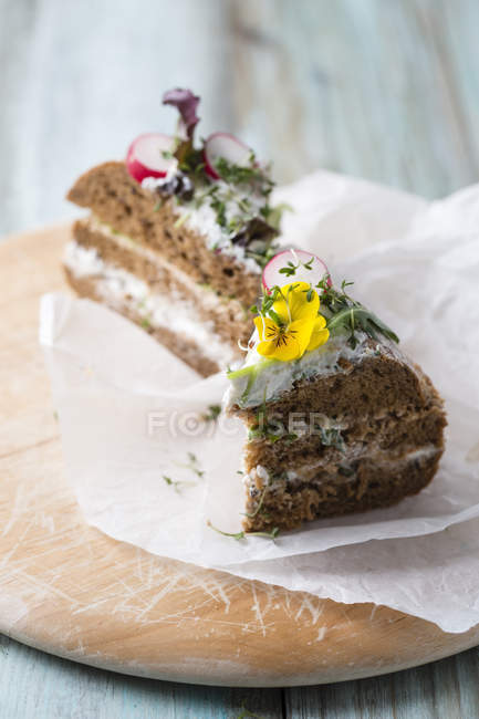 Bolo de pão em camadas com queijo creme, rabanetes vermelhos e flores comestíveis — Fotografia de Stock