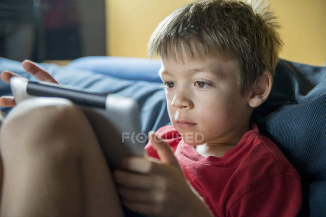 Маленький хлопчик в домашніх умовах використовуючи цифровий планшетний — стокове фото