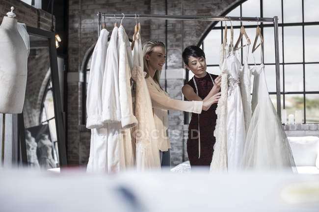 Concepteur de robe de mariée et mariée de parler en magasin nuptiale — Photo de stock