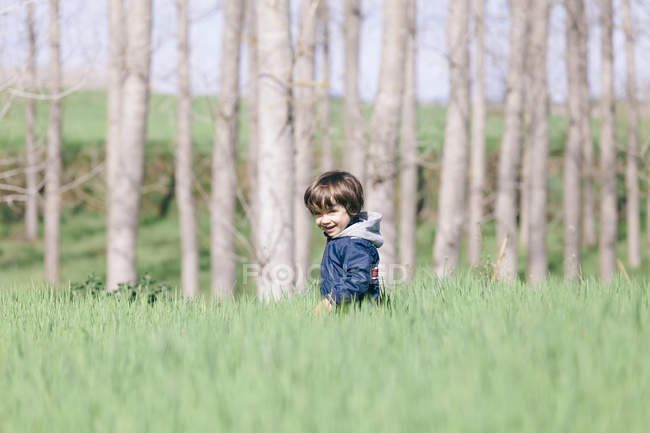 Ritratto di bambino che cammina in un campo di erba verde — Foto stock