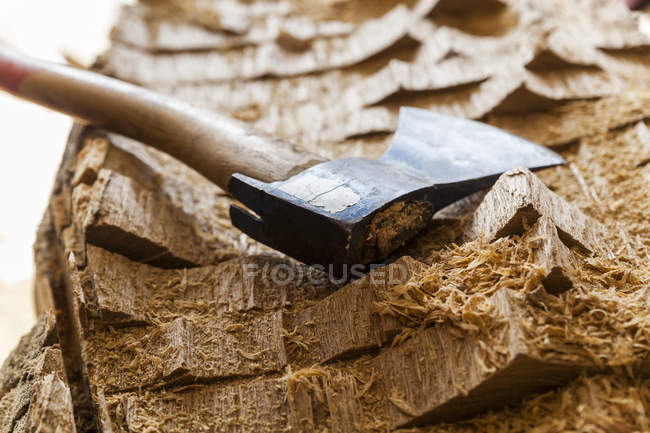Axe on wood block prepared for sculpting — Stock Photo