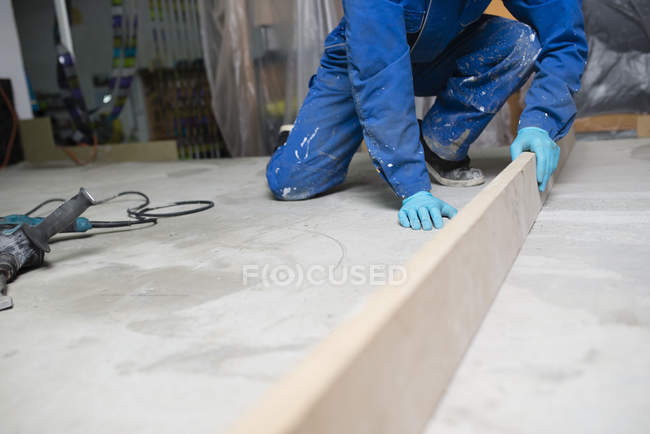 Operaio che controlla il livello del pavimento di cemento — Foto stock