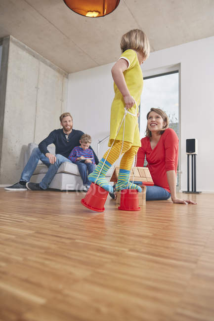Famille à la maison avec fille marchant sur des seaux — Photo de stock