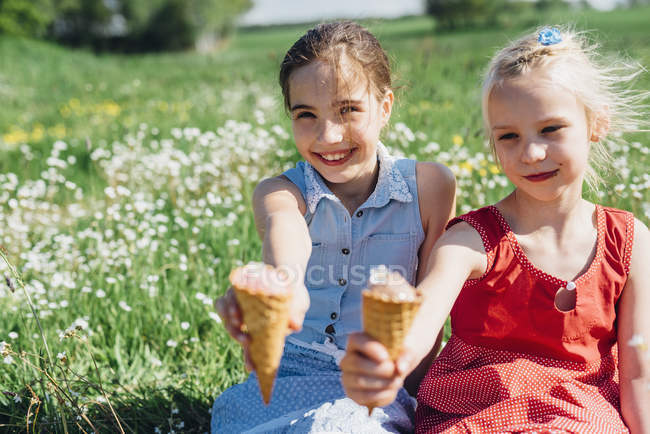 Meninas no prado segurando sorvete — Fotografia de Stock
