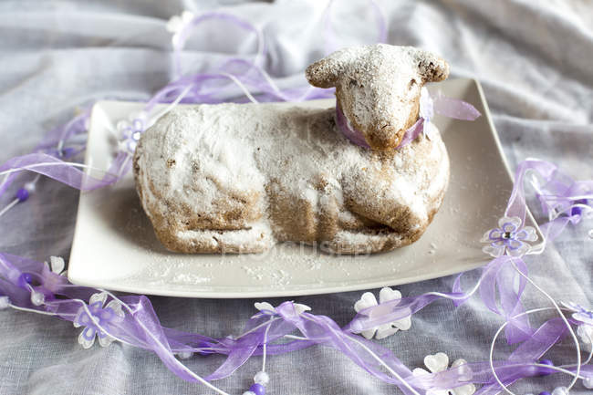 Vista ravvicinata della torta di agnello pasquale su piatto con nastri — Foto stock