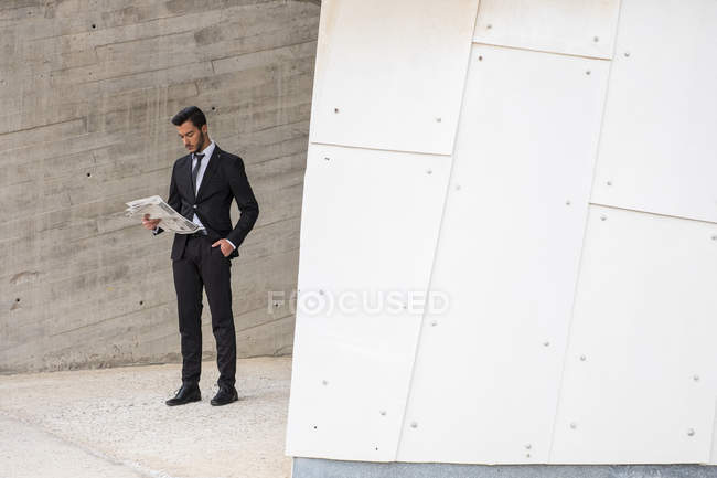 Homme d'affaires portant costume noir lecture journal — Photo de stock