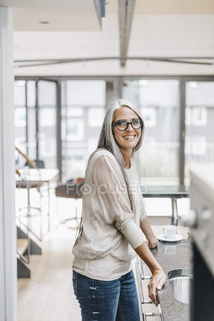 Lächelnde Frau mit langen grauen Haaren in der Küche — Stockfoto