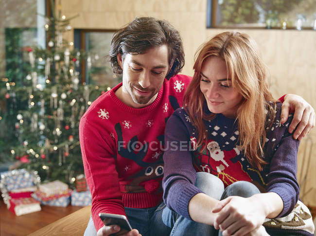 Happy couple taking selfie in front of Christmas tree — Stock Photo