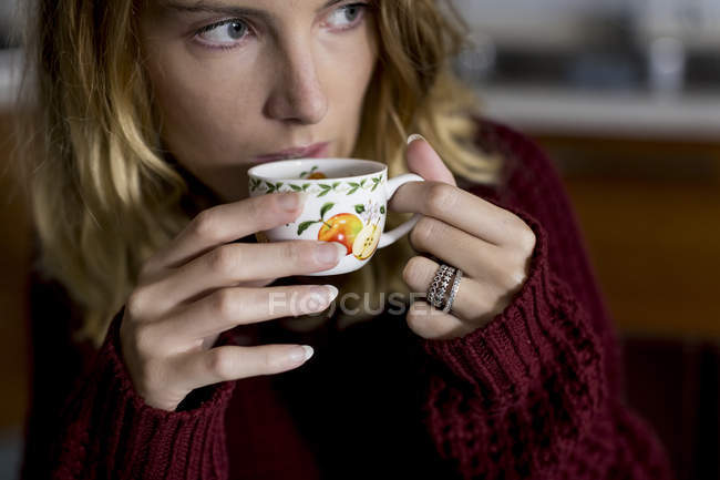 Жінка п'є чашку кави вдома — стокове фото