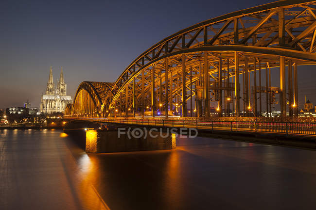Deutschland, Köln, Blick auf beleuchtete Brücke über Wasser — Stockfoto