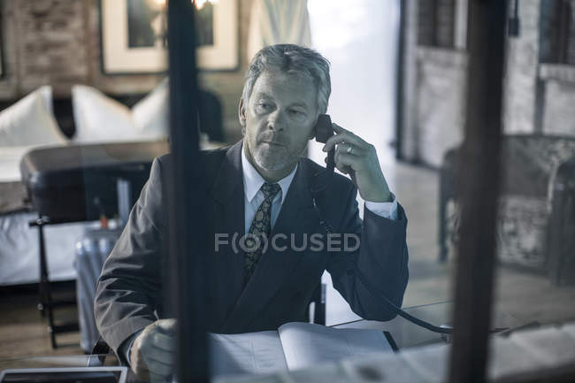 Homme parlant au téléphone dans la chambre d'hôtel — Photo de stock