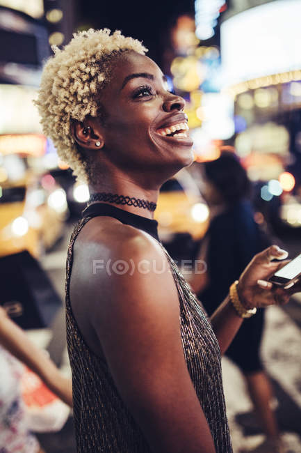 Afro-américaine avec téléphone portable sur Times Square la nuit, NY, USA — Photo de stock