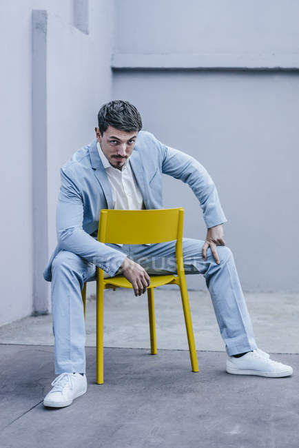 Ritratto di uomo d'affari sicuro seduto sulla sedia gialla — Foto stock
