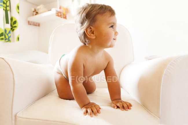 Bambino sorridente con i pannolini su una poltrona — Foto stock