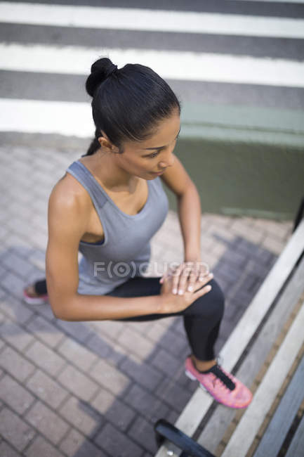 Donna che si estende su una panchina — Foto stock