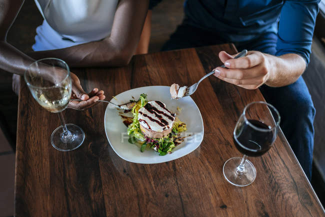 Primer plano de una pareja comiendo juntos en el restaurante - foto de stock