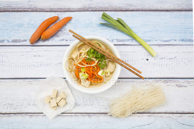 Cuenco de sopa de miso con tofu orgánico, fideos de zanahoria, chirivía, puerro, fideos de vidrio y perejil - foto de stock