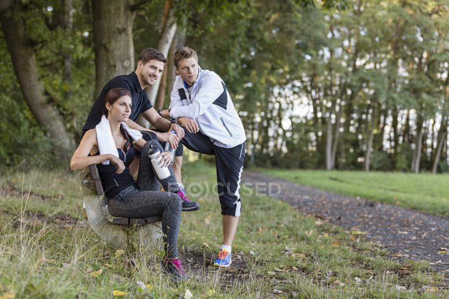Athletes resting after training on park bench — Stock Photo