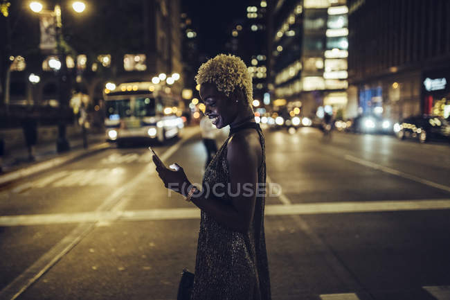 Heureuse femme afro-américaine avec téléphone portable sur Times Square la nuit, NY, USA — Photo de stock