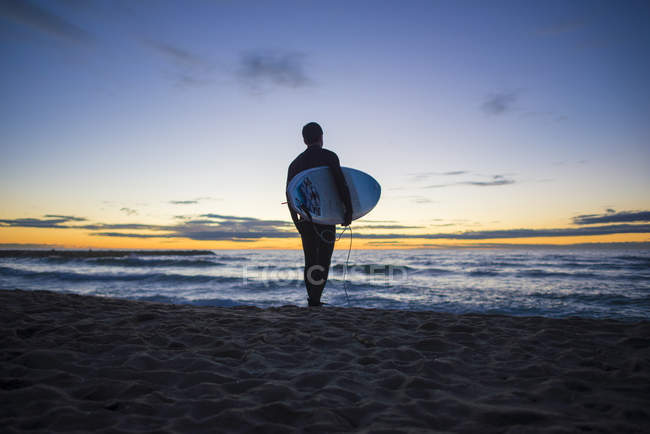 Surfista all'alba sulla spiaggia — Foto stock