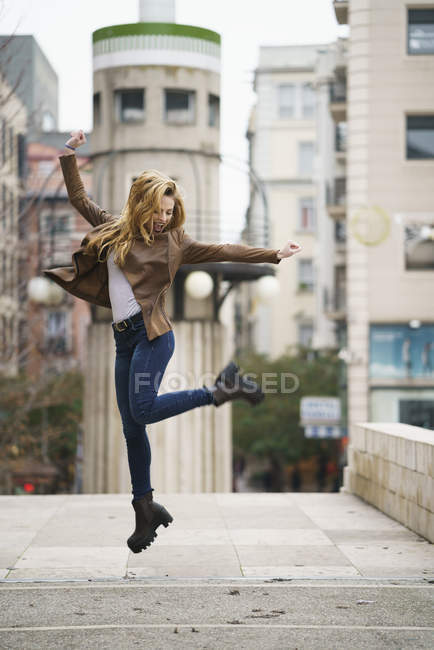 Excited young woman jumping in the air — Stock Photo