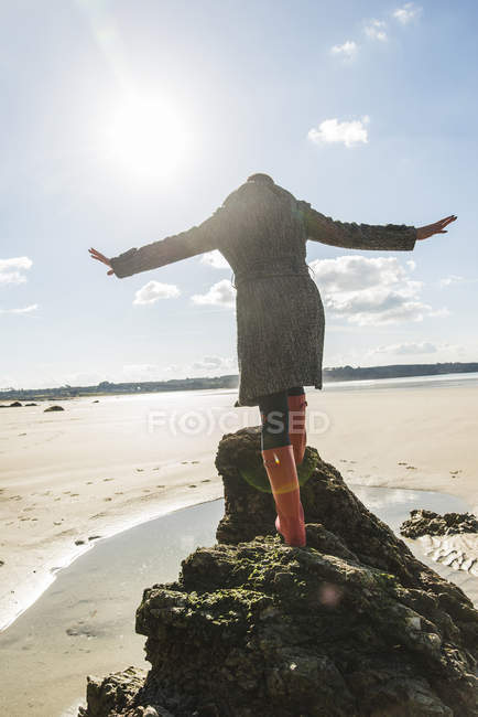 Woman balancing on rock at beach, France, Bretagne, Finistere, Crozon peninsula — Stock Photo