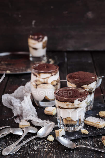 Vista da vicino dei bicchieri Tiramisu con biscotti e cucchiai — Foto stock