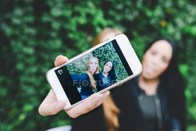 Two friends showing selfie on smart phone — Stock Photo