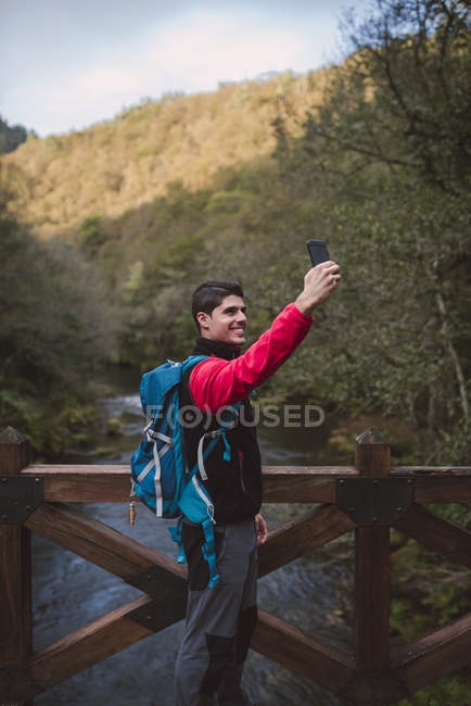 Турист делает селфи на природе со смартфоном — стоковое фото