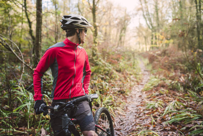 Mountain bike guardando indietro in pista nel bosco — Foto stock