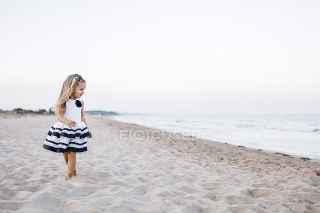 Милий кавказька дівчинка веселяться на піщаному пляжі — стокове фото