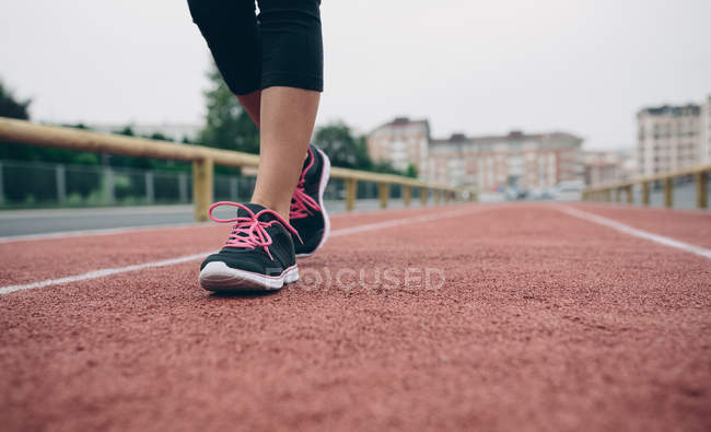 Imagem cortada de mulher andando na pista de tartan — Fotografia de Stock