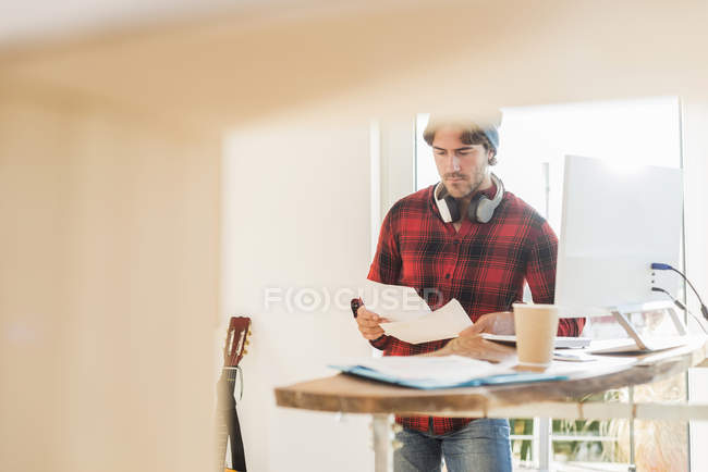Giovane uomo smistamento di documenti a casa — Foto stock