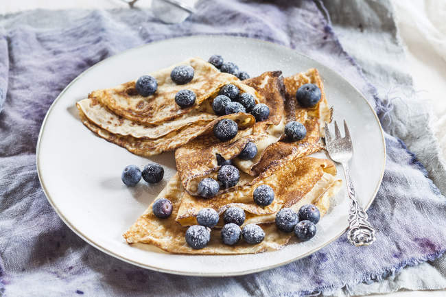 Crêpes mit Blaubeeren bestreut mit Puderzucker auf Teller — Stockfoto