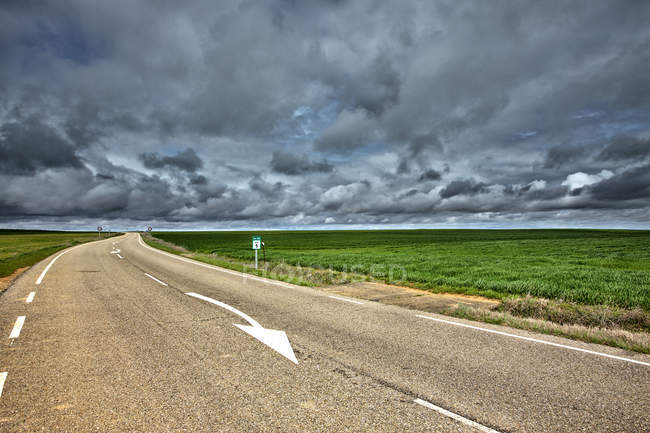 Spagna, Provincia di Zamora, strada vuota sotto il cielo nuvoloso — Foto stock