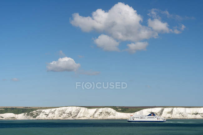 UK, Dover, ferry passing in front of chalk cliffs — Stock Photo