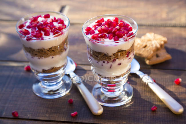 Desserts in glasses, pomegranate seeds yogurt and speculoos — Stock Photo