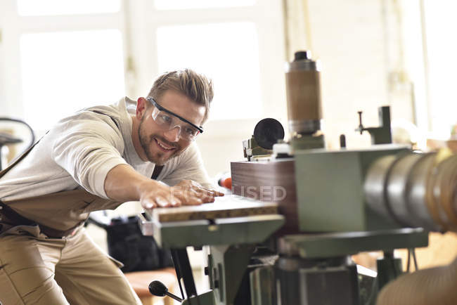 Carpenter using belt sander in his workshop — Stock Photo