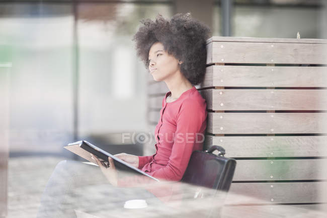 Donna seduta su panchina che tiene le lime — Foto stock