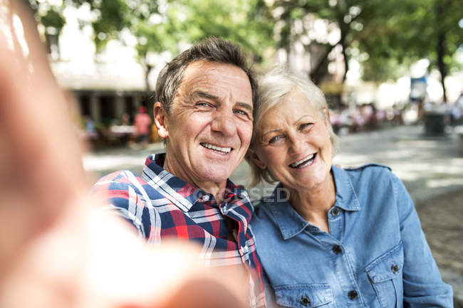 Happy cute senior couple taking selfie at park — Stock Photo