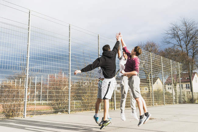 Юноши играют в баскетбол на открытом воздухе — стоковое фото