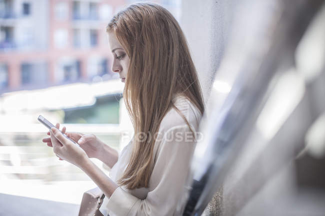 Junge Geschäftsfrau nutzt Smartphone — Stockfoto