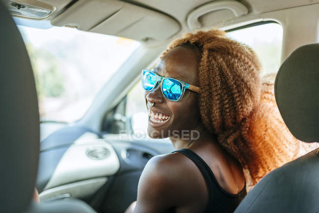 Feliz joven negro mujer en un coche - foto de stock