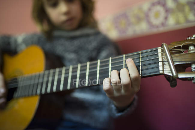 Close Up Of Boy Playing Spanish Guitar At Home Fingerboard Detail Stock Photo 177232050