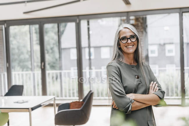 Porträt einer lächelnden Frau mit langen grauen Haaren im Amt — Stockfoto