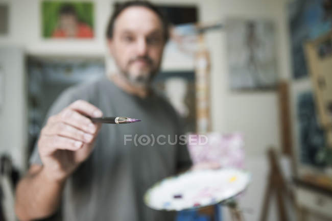 Close-up of Painter holding brush in studio — Stock Photo