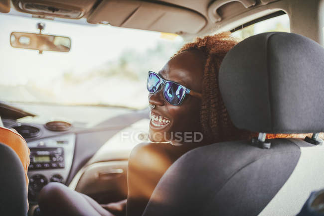 Mujer joven feliz en un coche - foto de stock