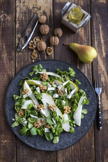 Top view of lettuce with pear, gorgonzola and walnuts on plate — Stock Photo