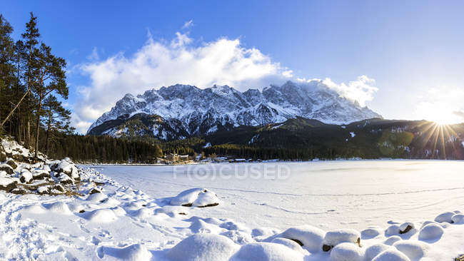 Германия, Бавария, Замерзшее озеро Эйбзе с горами Цугшпитце на заднем плане — стоковое фото