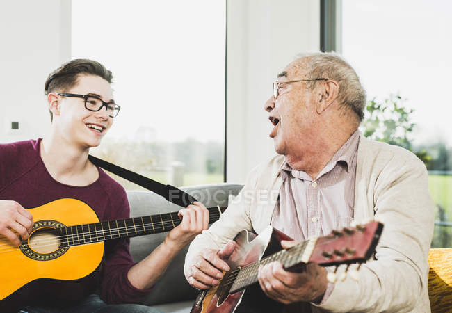 Senior singt und spielt mit Enkel Gitarre — Stockfoto